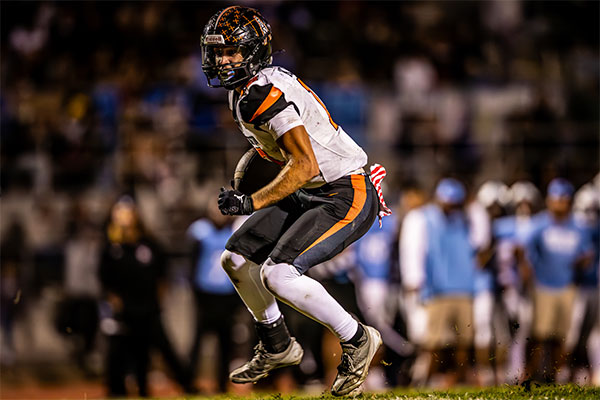 Huntington Beach Oiler tucking the ball and turning up field for a gain of yards.