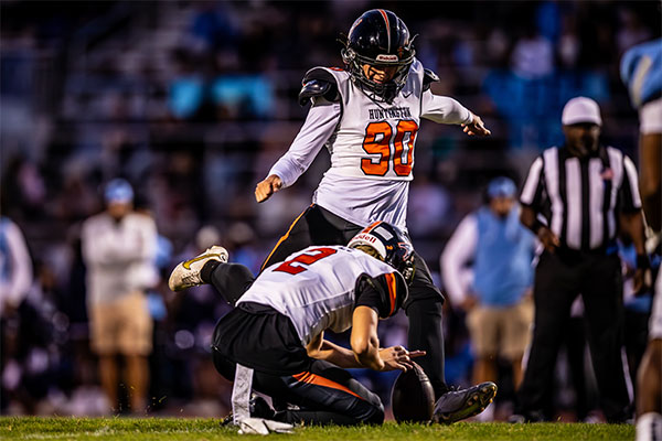 Mattheo Zavala (#90) kicking for a PAT as Nikko Lopez (#2) holds the ball in place.