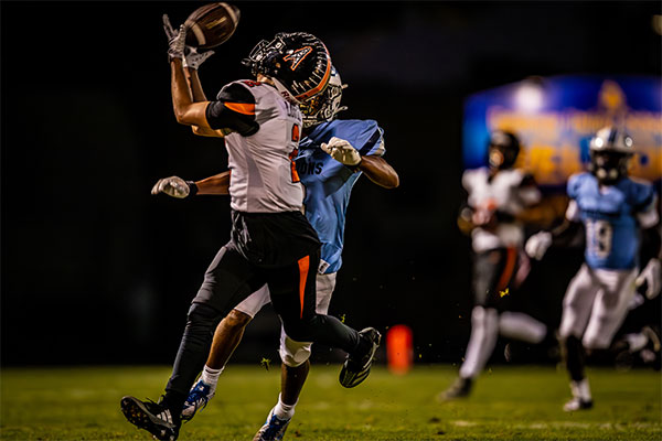 Niko Lopez (#2) reaching for the reception over his back shoulder.