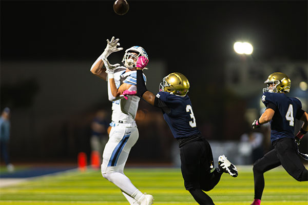 CdM receiver high points the ball to bring it down with a defender in his face.