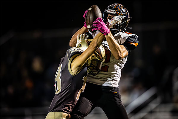 Niko Lopez (#2) securing the ball with the defender in his face.