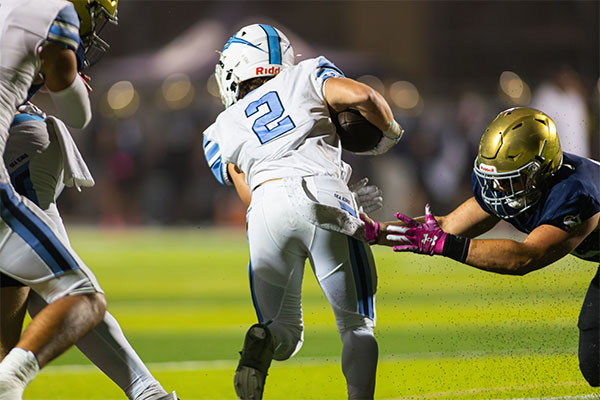 Wyatt Lucas (#2) slipping passed defenders to gain some more yards.